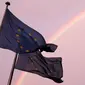 Sebuah pelangi terlihat di dekat bendera Eropa berkibar di Brussels, Belgia, (7/7/2015). (REUTERS/Francois Lenoir)