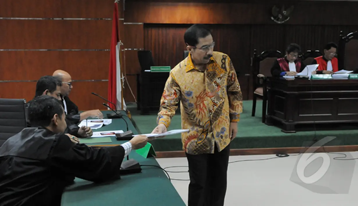 Romi Herton memberikan salinan naskah kepada para Jaksa Penuntut Umum di Tipikor, Jakarta, Senin (23/2/2015).  Romi kembali menjalani sidang lanjutan di Pengadilan Tipikor Jakarta dengan agenda pembacaan Pleidoi. (Liputan6.com/Herman Zakharia)