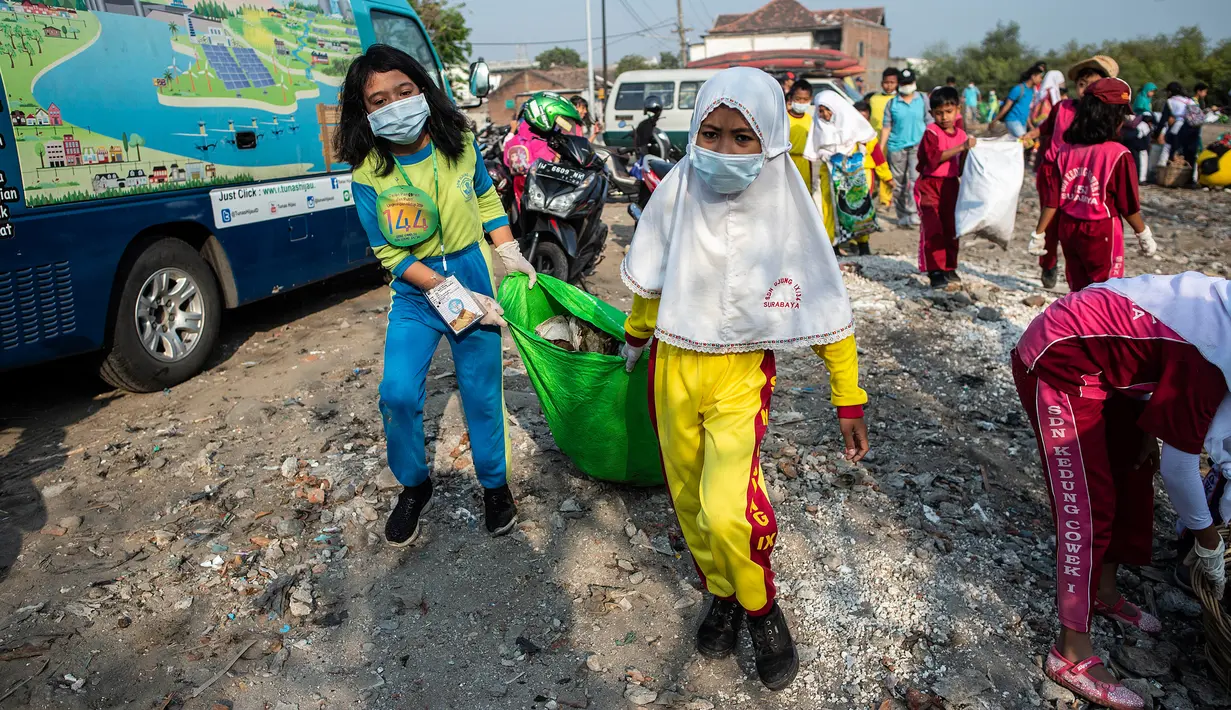 Anak-anak mengikuti aksi bersih sampah pada rangkaian kegiatan World Cleanup Day di kawasan pantai di Surabaya, Jawa Timur, Sabtu (21/9/2019). World Cleanup Day adalah sebuah gerakan bersih-bersih sampah terbesar di dunia yang dilaksanakan secara serentak di 157 negara.  (JUNI KRISWANTO / AFP)