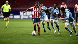 Penyerang Atletico Madrid,  Angel Correa (tengah) berlari membawa bola dari kawalan para pemain Celta Vigo pada pertandingan lanjutan La Liga Spanyol di stadion Wanda Metropolitano di Madrid, Spanyol, Selasa (9/2/2021). Atletico bermain imbang atas Celta Vigo 2-2. (AP Photo/Jose Breton)