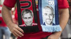 Seorang fans mengenakan slayer bergambar pelatih Manchester City,  Pep Guardiola (kanan) dan pelatih  Manchester United, Jose Mourinho,  pada laga Premier League di Old Trafford, Manchester,  (10/9/2016). (AFP/Oli Scarff)