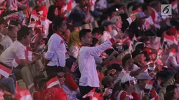 Sejumlah relawan pendukung mengibarkan bendera Merah Putih jelang menyaksikan pidato Visi Indonesia yang akan disampaikan Presiden/Wakil Presiden terpilih 2019-2024, Joko Widodo dan KH Ma’ruf Amin di SICC, Kab Bogor, Jawa Barat, Minggu (14/7/2019). (Liputan6.com/Helmi Fithriansyah)