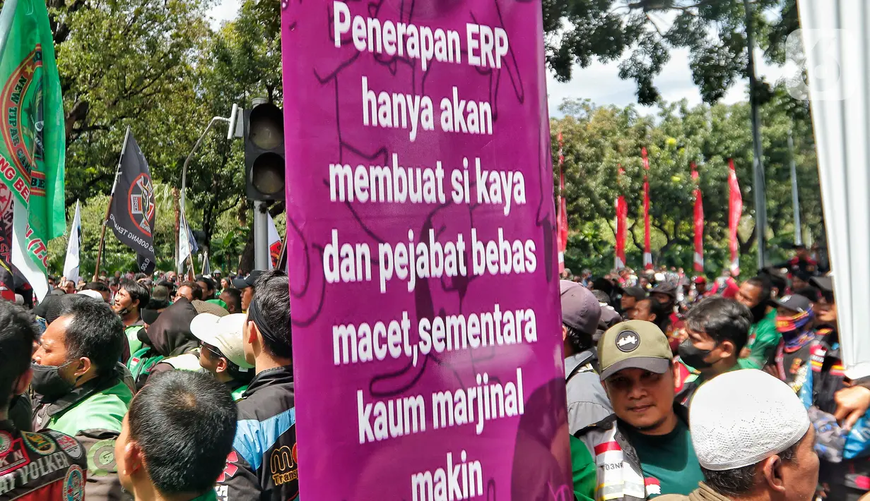 Pengemudi ojek online membentangkan spanduk tuntutan saat melakukan aksi di depan Balai Kota Jakarta, Rabu (8/2/2023). Dalam aksinya, mereka menolak penerapan jalan berbayar atau electronic road pricing (ERP) diterapkan di Jakarta. (Liputan6.com/Angga Yuniar)