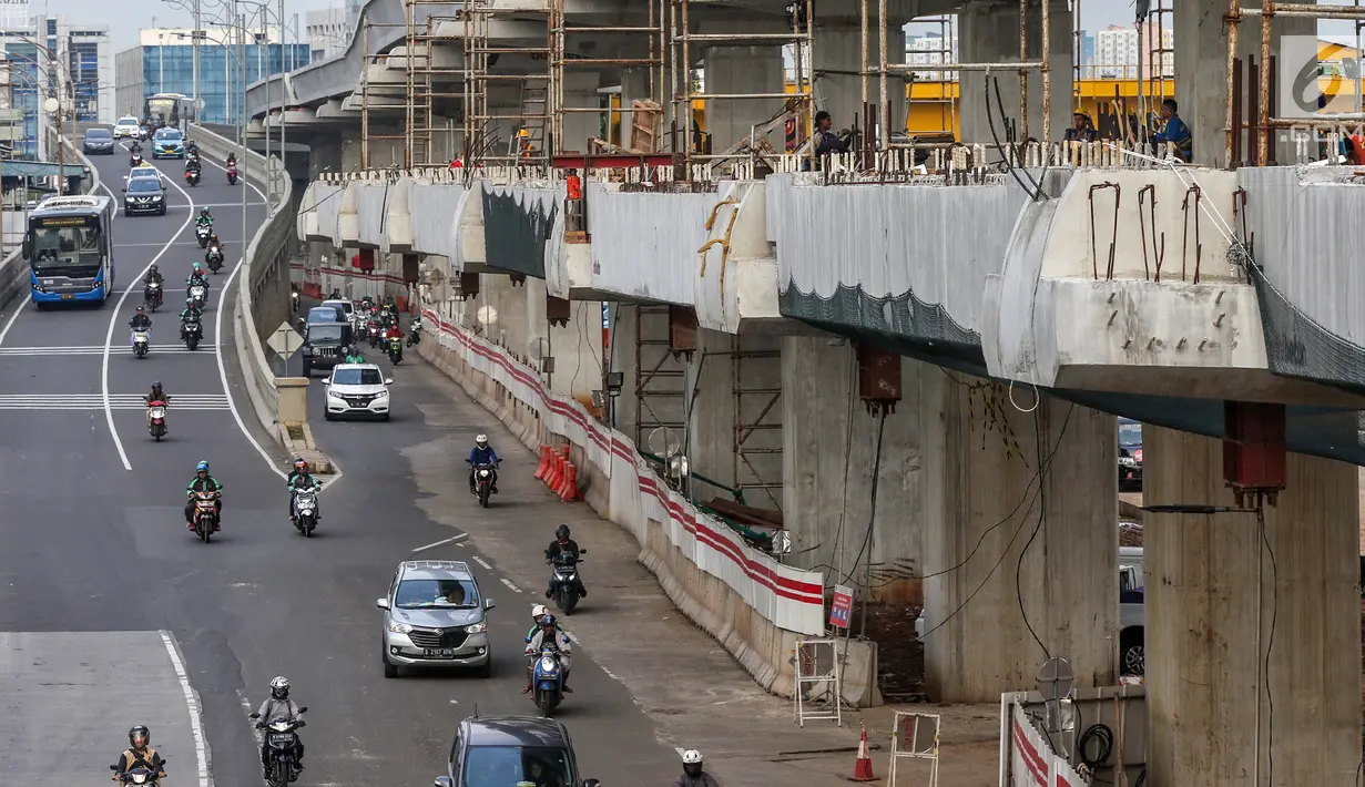 Pengendara bermotor melintasi lokasi pembangunan jalur kereta ringan atau Light Rail Transit (LRT) Jabodebek rute Cawang-Dukuh Atas di Cawang, Jakarta, Senin (29/4/2019). Pembangunan jalur LRT Cawang-Kuningan-Dukuh Atas yang mencapai 47,95 persen (data akhir Maret 2019). (Liputan6.com/Johan Tallo)