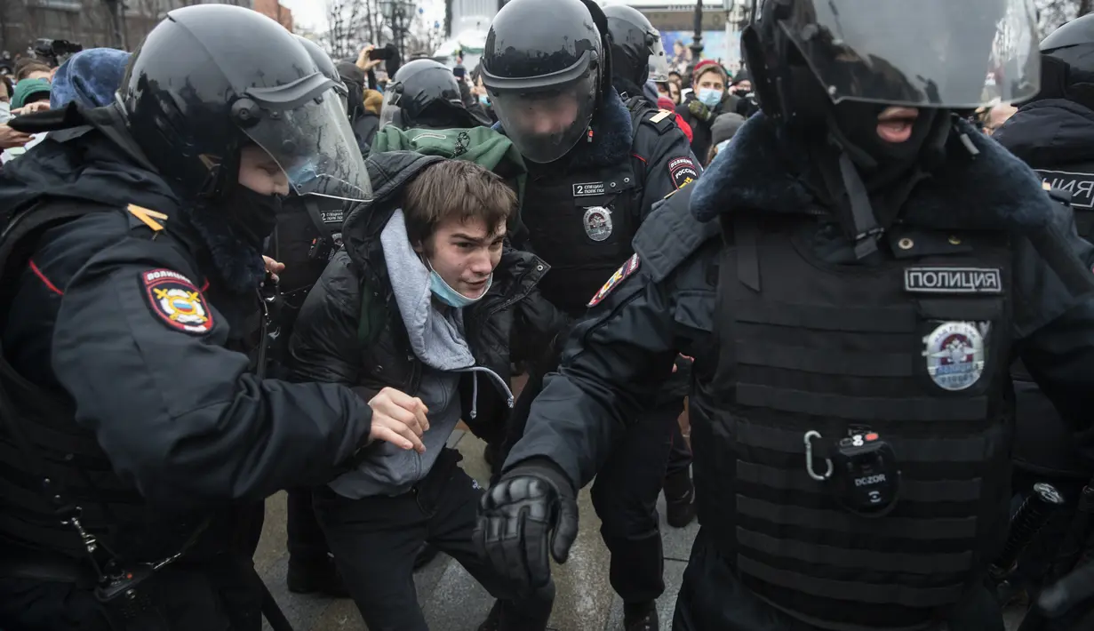 Petugas polisi menahan seorang pria selama protes terhadap pemenjaraan pemimpin oposisi Alexei Navalny di Moskow, Rusia, Sabtu (23/1/2021). 795 penangkapan dilakukan di ibu kota Moskow. (AP Photo/Pavel Golovkin)