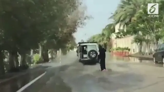 Kreasi tanpa batas dilakukan oleh wanita Arab ini. Ia berselancar di jalan yang terendam oleh banjir.
