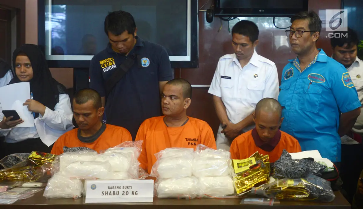 Petugas BNN menunjukkan tiga tersangka berserta barang bukti sabu seberat 20 Kg saat rilis di Kantor BNN, Jakarta, Kamis (26/4). Sabu tersebut diselundupkan dari Malaysia ke Dumai. (Merdeka.com/Imam Buhori)