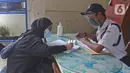 Pasien sembuh COVID-19 mengisi data penjemputan seusai meninggalkan ruangan isolasi Graha Wisata Ragunan di Jakarta, Jumat (29/1/2021). Sebanyak 68 pasien covid-19 dari total 81 pasien yang melakukan isolasi di tempat tersebut telah dinyatakan sembuh. (Liputan6.com/Herman Zakharia)
