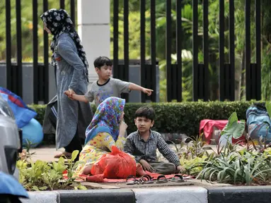 Sejumlah imigran duduk di trotoar depan Kantor UNHCR Menara Ravindo, Kebon Sirih, Jakarta, Rabu (3/7/2019). Puluhan imigran yang sebelumnya menetap di Kalideres kini terlantar di trotoar depan Menara Ravindo. (merdeka.com/Iqbal Nugroho)