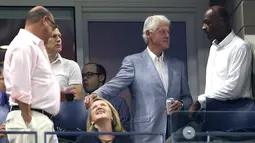 Mantan presiden AS, Bill Clinton (dua kanan) berbincang saat menonton pertandingan antara Roger Federer dan John Millman di AS Terbuka 2018, New York, Senin (3/9). (ALEX PANTLING/GETTY IMAGES NORTH AMERICA/AFP)