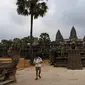 Sejumlah wisatawan berjalan di Candi Angkor Wat, Provinsi Siem Reap, Kamboja, Kamis (5/3/2020). Menurut World Travel and Tourism Council, wabah virus corona (COVID-19) membuat sektor pariwisata dunia kehilangan USD 22 miliar. (TANG CHHIN Sothy/AFP)