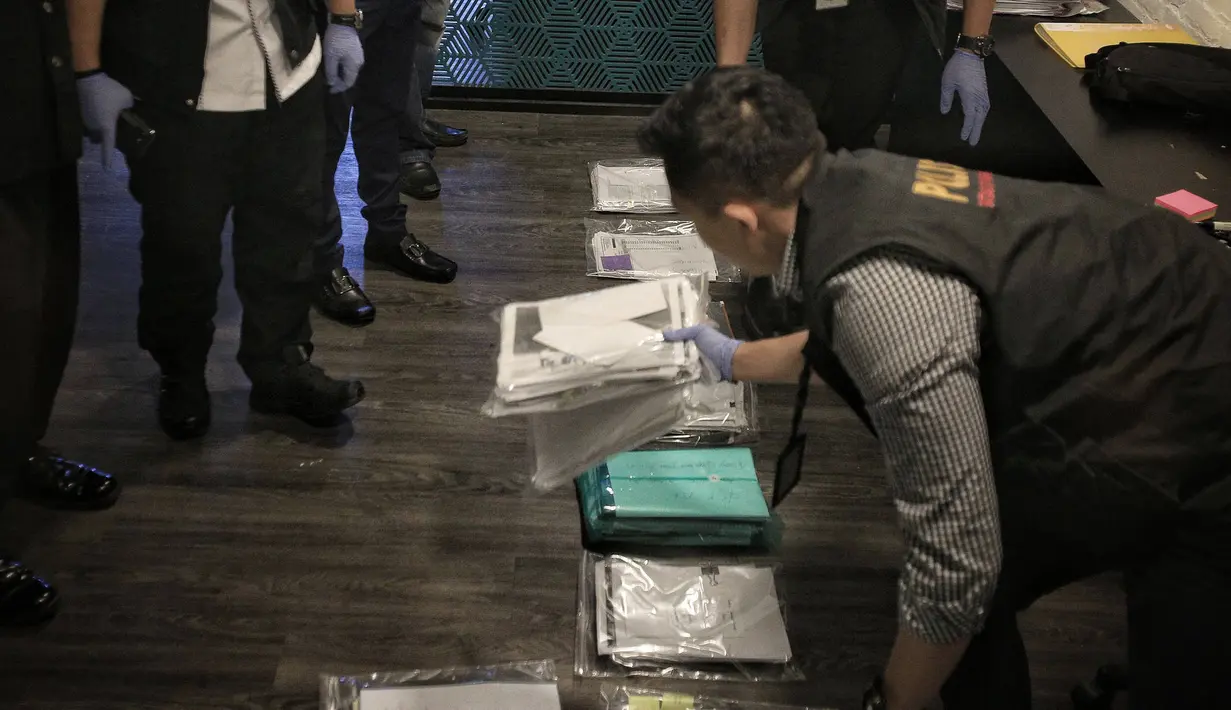 Satgas Anti Mafia Bola Polri mengamankan barang bukti hasil penggeledahan dari kantor PSSI di FX Tower, Jakarta, Rabu (30/1). Dokumen tersebut berkaitan dengan anggaran tahun 2017 dan 2018 dari PSSI. (Liputan6.com/Faizal Fanani)