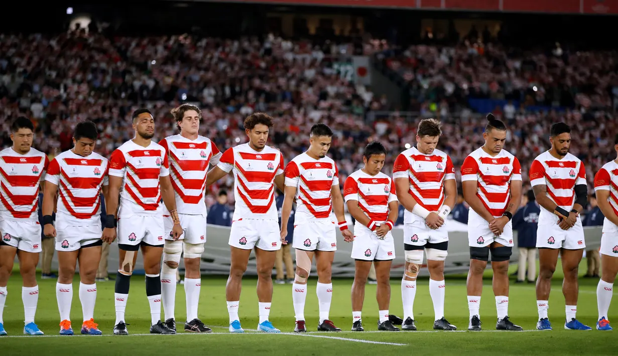 Pemain rugby Jepang berdoa untuk korban Topan Hagibis sebelum melawan Skotlandia di Piala Dunia Rugbi 2019 di Stadion Internasional Yokohama (13/10/2019). Jepang menyingkirkan Skotlandia dengan skor 28-21 dan melaju ke perempat final. (AFP Photo/Odd Andersen)