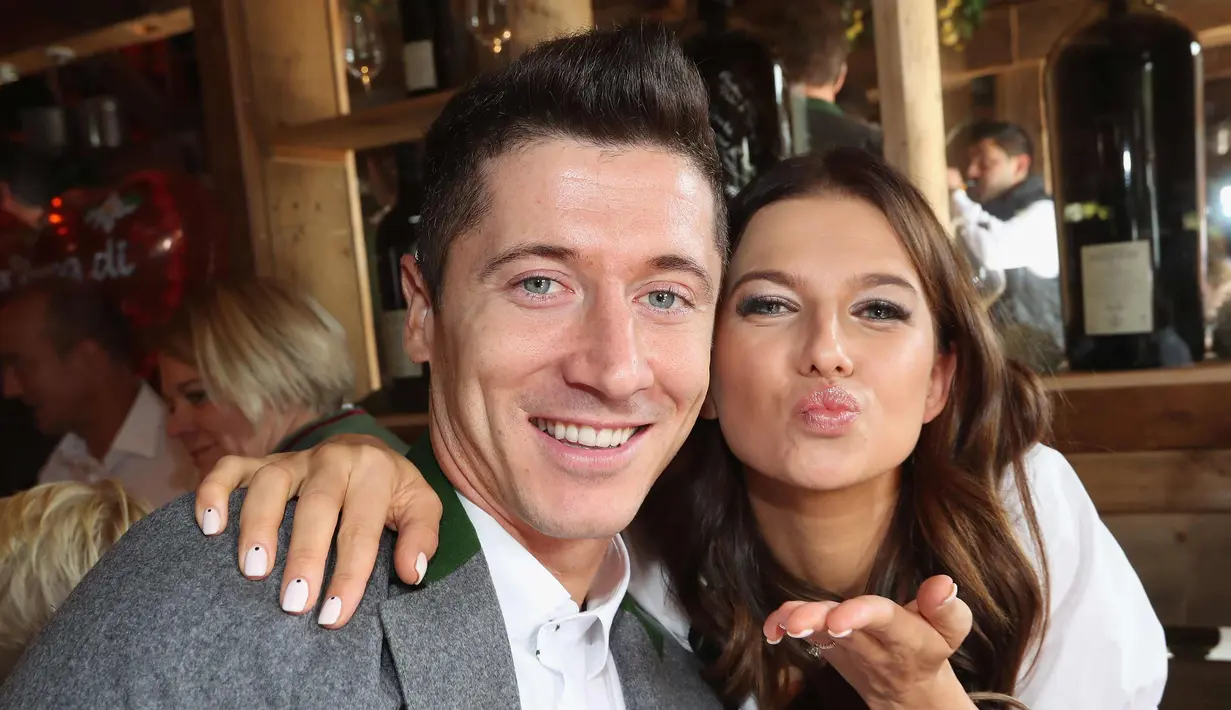 Penyerang Bayern Munchen, Robert Lewandowski bersama istrinya, Anna berpose saat menghadiri festival bir Oktoberfest 2017 di Munich, Jerman (23/9). (AFP Photo/Pool/Alexandra Beier)