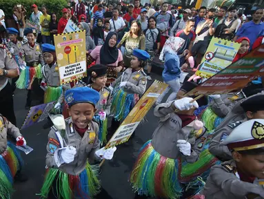 Puluhan polisi cilik berjoged saat melakukan kampanye keselamatan berkendara di kawasan Bundaran HI, Jakarta, Minggu (12/3). Kampanye tersebut diadakan guna mengajak pengguna jalan agar tertib dalam berlalu lintas. (Liputan6.com/Immanuel Antonius)