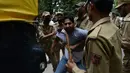 Seorang PNS ditahan petugas kepolisian saat aksi unjuk rasa di Srinagar, India, Senin (10/8/2015). Dalam aksinya, para PNS tersebut menuntut pembayaran gaji mereka yang tertunggak. (AFP PHOTO/Tauseef MUSTAFA)
