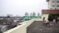 Sejumlah remaja bermain futsal di atas gedung di Pasar Mampang, Jakarta, Rabu (12/7). Karena kurangnya lahan tempat bermain futsal di jakarta sehingga atas gedung menjadi tempat bermain tanpa menghiraukan keselamatan. (Liputan6.com/Faizal Fanani)
