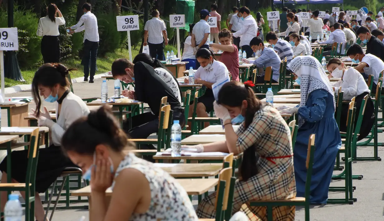 Para siswa Uzbekistan mengikuti ujian masuk luar ruangan, di tengah pandemi COVID-19 yang sedang melanda, di Tashkent pada Rabu (2/9/2020). (Photo by Yuri KORSUNTSEV / AFP)