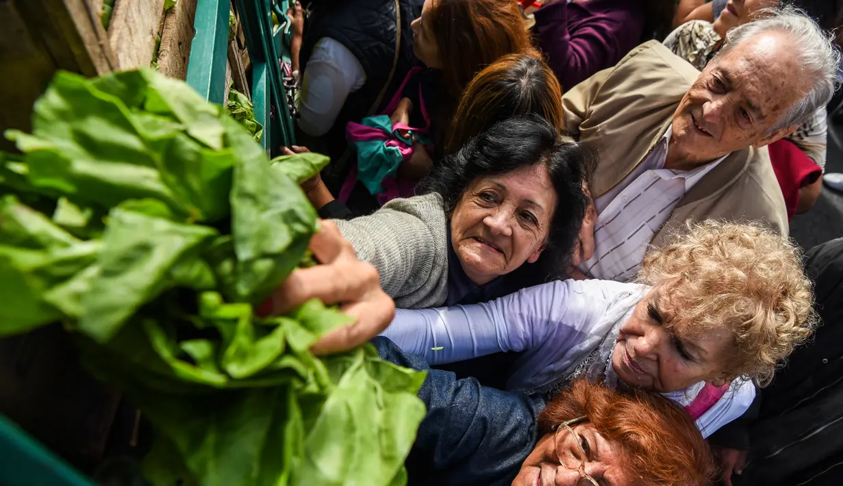 Warga mengambil sayur yang dibagikan secara gratis oleh petani di Buenos Aires, Senin (24/4). Aksi tersebut sebagai bentuk protes tingginya biaya hidup yang dianggap memberatkan petani. (AFP FOTO / Eitan ABRAMOVICH)