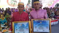 Pemain PSM, M. Rahmat Syamsuddin dan M. Syaiful, tampil gagah dengan kostum adat saat menghadiri peringatan ulangtahun ke-58 Kabupaten Takalar, Senin (12/2/2018). (Bola.com/Abdi Satria)
