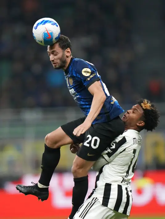 Pemain Inter Milan Hakan Calhanoglu (kiri) berebut bola dengan pemain Juventus Weston McKennie pada pertandingan Serie A di Stadion San Siro, Milan, Italia, Minggu (24/10/2021).  Pertandingan berakhir dengan skor 1-1. (AP Photo/Luca Bruno)