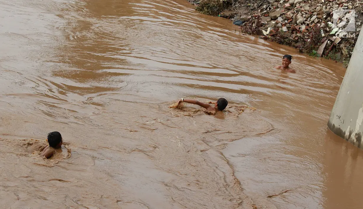 Anak-anak berenang di Sungai Ciliwung yang meluap di kawasan Rawajati, Jakarta, Jumat (26/4). Tingginya volume debit air yang berasal dari Bogor tidak menyurutkan niat anak-anak itu untuk tetap berenang, meskipun berbahaya bagi keselamatan. (Liputan6.com/Immanuel Antonius)