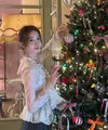 Yoona berpose di depan pohon Natal yang dihiasi dengan banyak pita. Ia tampil mengenakan atasan lengan panjang lace dipadukan kalung mutiara. [@yoona_lim]