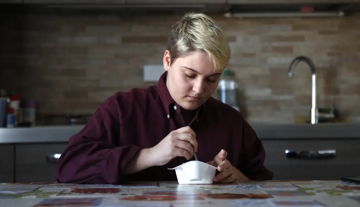 Matteo Coccimiglio menyantap sarapannya di Roma, 18 Maret 2021. Sekolah seni Ripetta di Roma baru-baru ini bergabung dengan beberapa sekolah menengah di Italia yang memberikan siswa transgender hak untuk dikenal dengan nama selain yang diberikan saat mereka lahir. (AP Photo/Alessandra Tarantino)