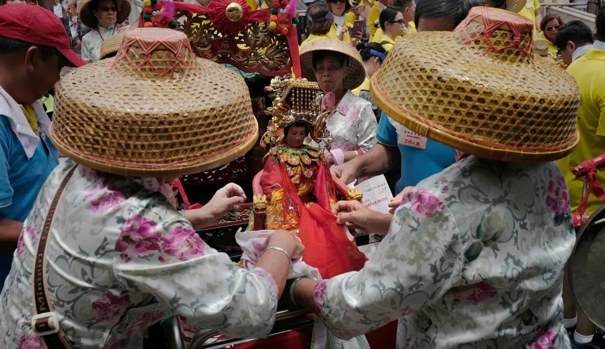 Sejumlah warga menyiapkan patung dewa saat Festival Cheung Chau Bun di Hong Kong (5/3). Festival ini diadakan oleh masyarakat di pulau kecil yang berada sekitar 10 kilometer dari Pulau Hong Kong yang bernama Pulau Cheung Chau. (AP Photo/Vincent Yu)