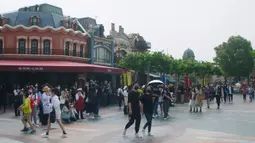 Wisatawan berjalan di taman hiburan Disneyland, Shanghai, China, Senin (11/5/2020). Walt Disney membuat langkah-langkah pencegahan dan antisipasi penyebaran COVID-19 saat kembali dibukanya Disneyland Shanghai. (AP Photo/Si Chen)