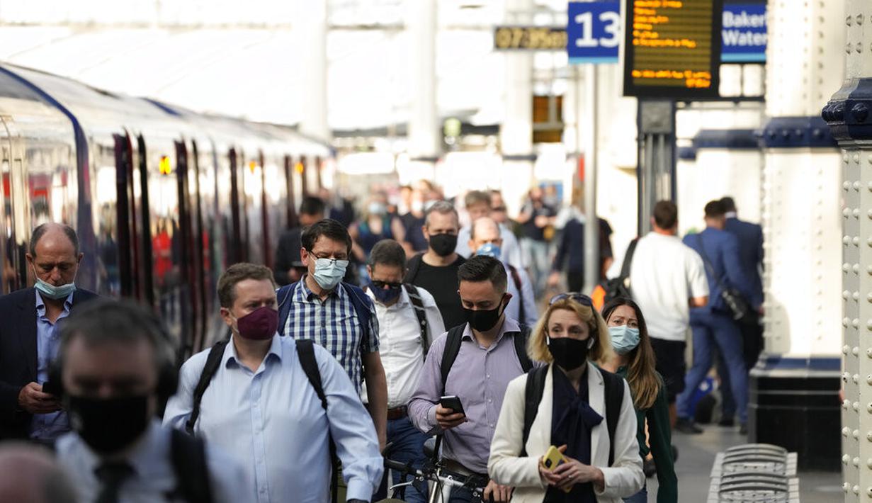 Orang-orang memakai masker setelah turun dari kereta api pada jam sibuk pagi hari di stasiun Waterloo di London, Rabu (13/7/2021). Wali Kota Sadiq Khan menekankan transportasi publik di London akan terus memberlakukan kewajiban memakai masker setelah Senin (19/7) mendatang. (AP Photo/Matt Dunham)