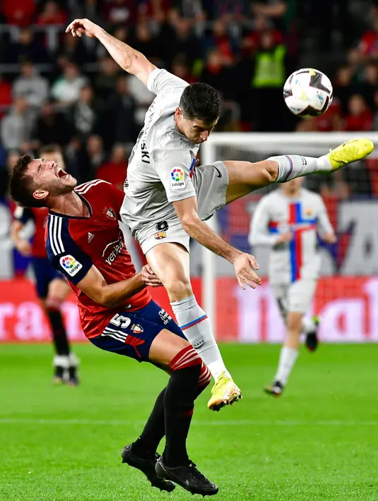 Pemain Osasuna David Garcia (kiri) berebut bola dengan pemain Barcelona Robert Lewandowski pada pertandingan sepak bola Liga Spanyol di Stadion El Sadar, Pamplona, Spanyol, 8 November 2022. Barcelona menang 2-1. (AP Photo/Alvaro Barrientos)