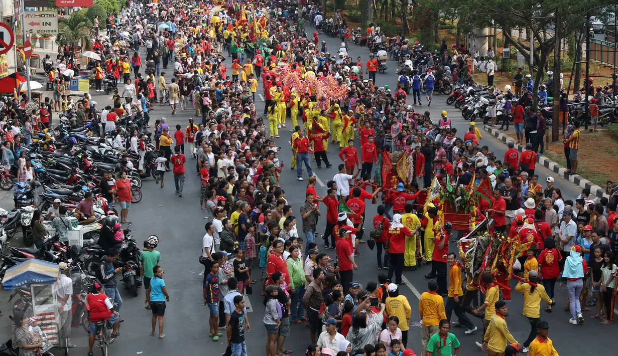 Warga memadati  ruas Jalan Hayam Wuruk, Jakarta Barat, ketika pawai kirab budaya melintas, Minggu (18/10/2015).  Sejumlah peserta pawai ini berasal dari 90 tempat ibadah Tridarma se-Indonesia. (Liputan6.com/Immanuel Antonius)
