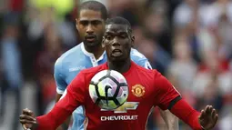 Gelandang Manchester United, Paul Pogba, berusaha melewati hadangan bek sayap Stoke, Glen Johnson. Bertindak sebagai tuan rumah Setan Merah lebih menguasai jalannya laga dengan penguasaan bola 63 persen. (Reuters/Carl Recine)
