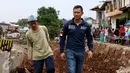 Bakal Cagub DKI, Agus Harimurti Yudhoyono bersama seorang warga menyusuri pinggiran Sungai Ciliwung di Bukit Duri, Jakarta, Kamis (20/10). Kunjungan Agus Yudhoyono untuk melihat langsung kondisi warga yang terkena gusuran. (Liputan6.com/Gempur M Surya)