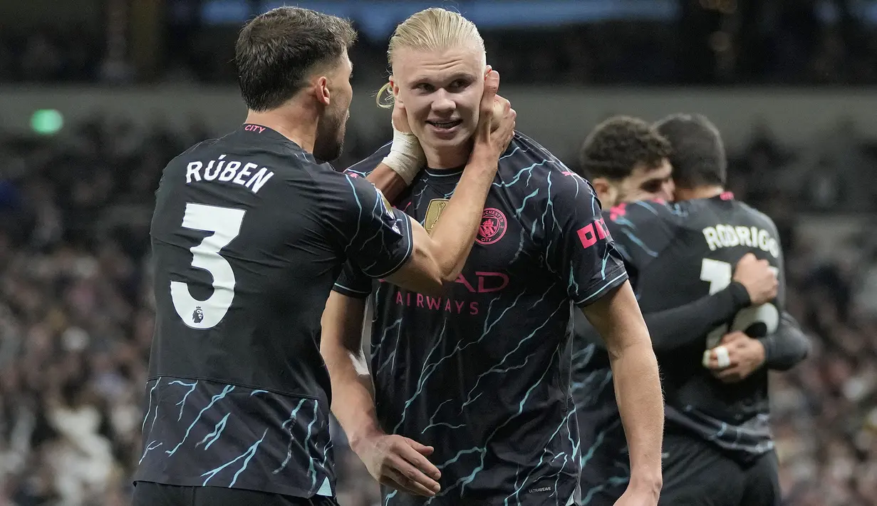Selebrasi striker Manchester City, Erling Haaland (kanan) bersama Ruben Dias setelah mencetak gol kedua timnya ke gawang Tottenham Hotspur lewat eksekusi penalti pada laga tunda pekan ke-34 Liga Inggris 2023/2024 di Tottenham Hotspur Stadium, London, Selasa (14/5/2024). (AP Photo/Kin Cheung)