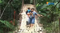 Warga terpaksa kembali menggunakan jembatan ini lantaran jembatan baru yang berjarak 20 meter dari jembatan lama ambruk tertimpa banjir.