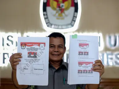 Kepala Subag Penyusunan Norma Desain dan Standar Kebutuhan Pemilu Biro Perencanaan Data KPU Sahono  menunjukan dua contoh surat suara untuk Pilkada Serentak 9 Desember 2015 di Gedung KPU, Jakarta, Rabu (11/11). (Liputan6.com/Faizal Fanani)
