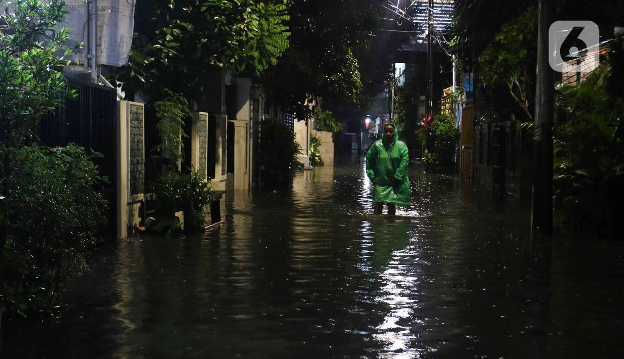 Warga sedang berjalan di tengah banjir yang melanda Jalan Bangka, Jakarta, Rabu (4/1/2023). Hujan deras yang terjadi pada Rabu sore membuat Kali Mampang meluap hingga menyebabkan banjir di kawasan tersebut dengan ketinggian bervariasi mulai dari 40 hingga 60 cm. (Liputan6.com/Herman Zakharia)