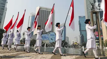 Sejumlah pasukan pengibar bendera (Paskibra) berbaris membawa bendera Merah Putih di Bundaran Hotel Indonesia (HI), Jakarta, Kamis (15/8/2024). (Liputan6.com/Herman Zakharia)