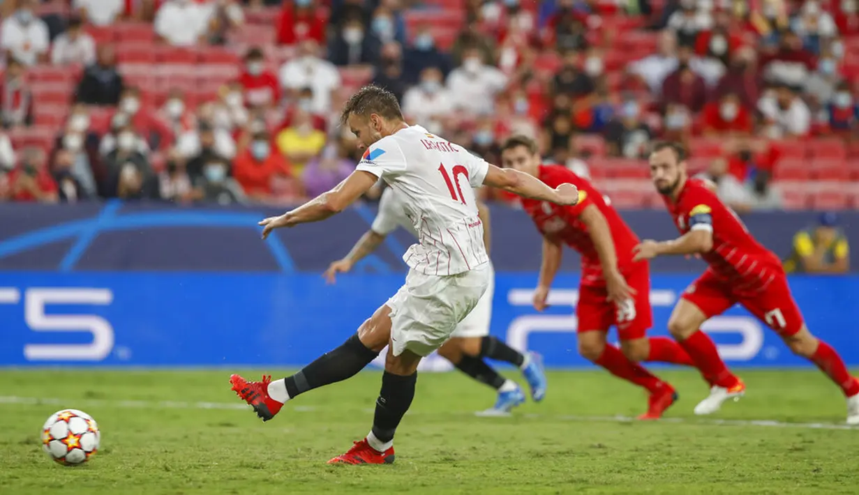 Pemain Sevilla Ivan Rakitic (kiri) mencetak gol ke gawang Salzburg pada pertandingan Grup G Liga Champions di Stadion Ramon Sanches Pizjuan, Seville, Spanyol, Selasa (14/9/2021). Pertandingan berakhir dengan skor 1-1. (AP Photo/Angel Fernandez)