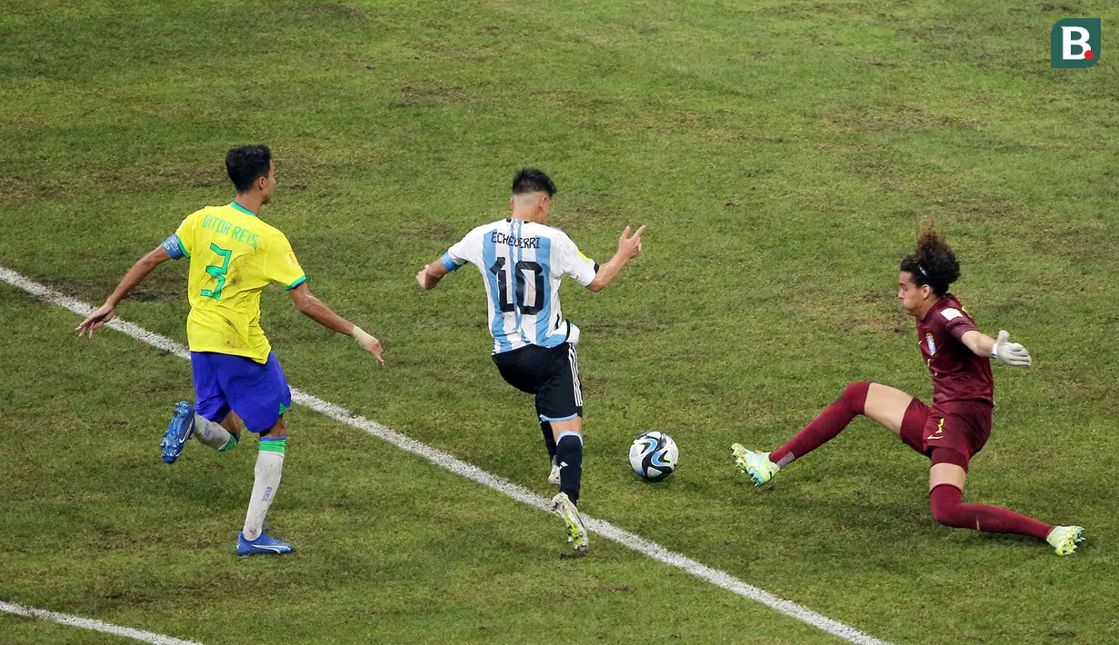 Aksi Pemain Timnas Argentina U-17, Claudio Echeverri (tengah), berhasil mengecoh kiper Brasil U-17, Phillipe Gabriel dan mencetak gol dalam pertandingan perempat final Piala Dunia U-17 2023 yang berlangsung di Jakarta International Stadium, Jumat (24/11/2023). (Bola.com/M Iqbal Ichsan)