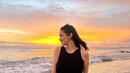 Aksen kacamata diletakkan di atas kepala Syifa. Pemain film Mohon Doa Restu ini berusaha mendapatkan foto terbaik saat main di pantai kala sunset. (Liputan6.com/IG/@syifahadju)