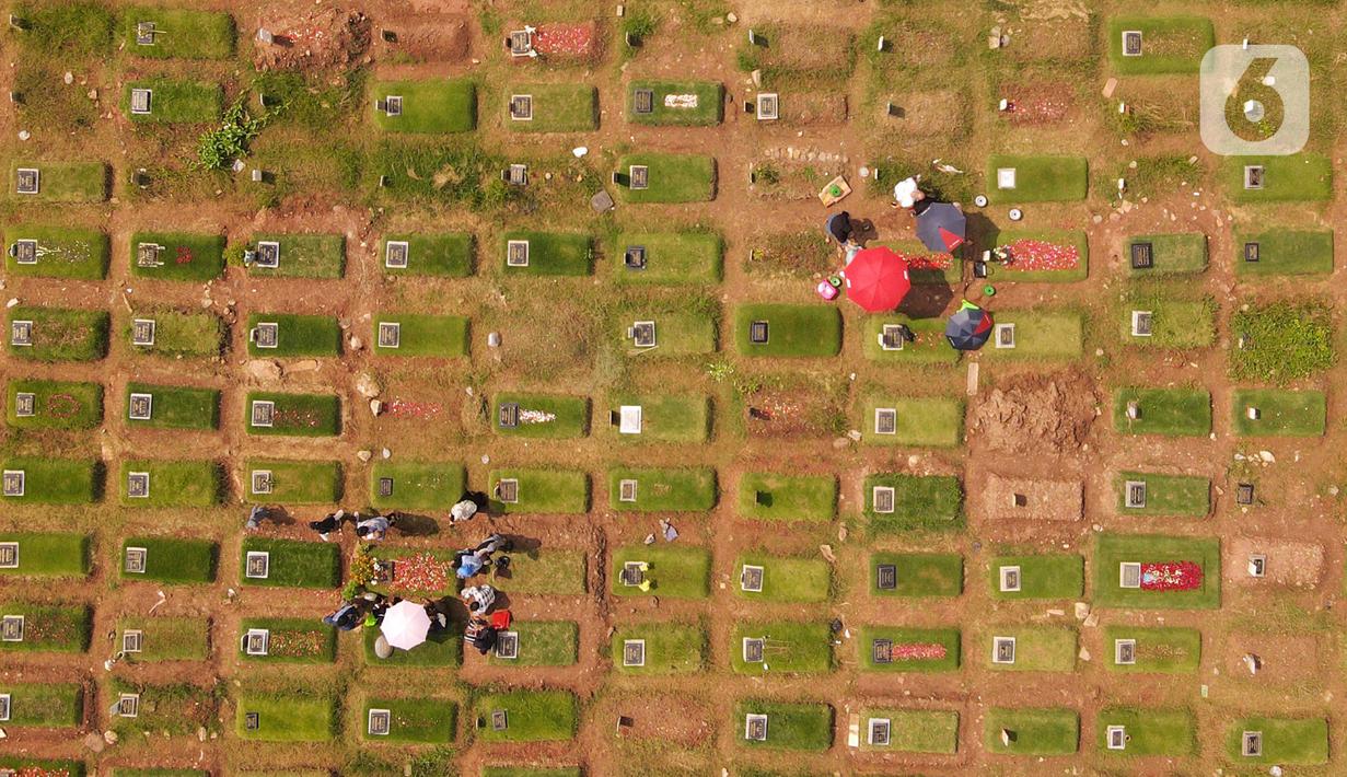 <p>Foto udara memperlihatkan warga berdoa saat berziarah di area pemakaman khusus COVID-19 di TPU Rorotan, Cilincing, Jakarta Utara, Rabu (4/5/2022). Sejumlah tempat pemakaman umum masih dipadati oleh keluarga yang melakukan ziarah di H+3 Lebaran. (merdeka.com/Imam Buhori)</p>