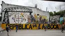 Anak-anak bermain sepak bola di taman bermain di lingkungan La Boca, ibu kota Argentina, Buenos Aires pada 27 November 2018. Kota ini dikenal sebagai markas dari Boca Juniors, tim yang pernah membesarkan Diego Maradona. (Ludovic MARIN / AFP)