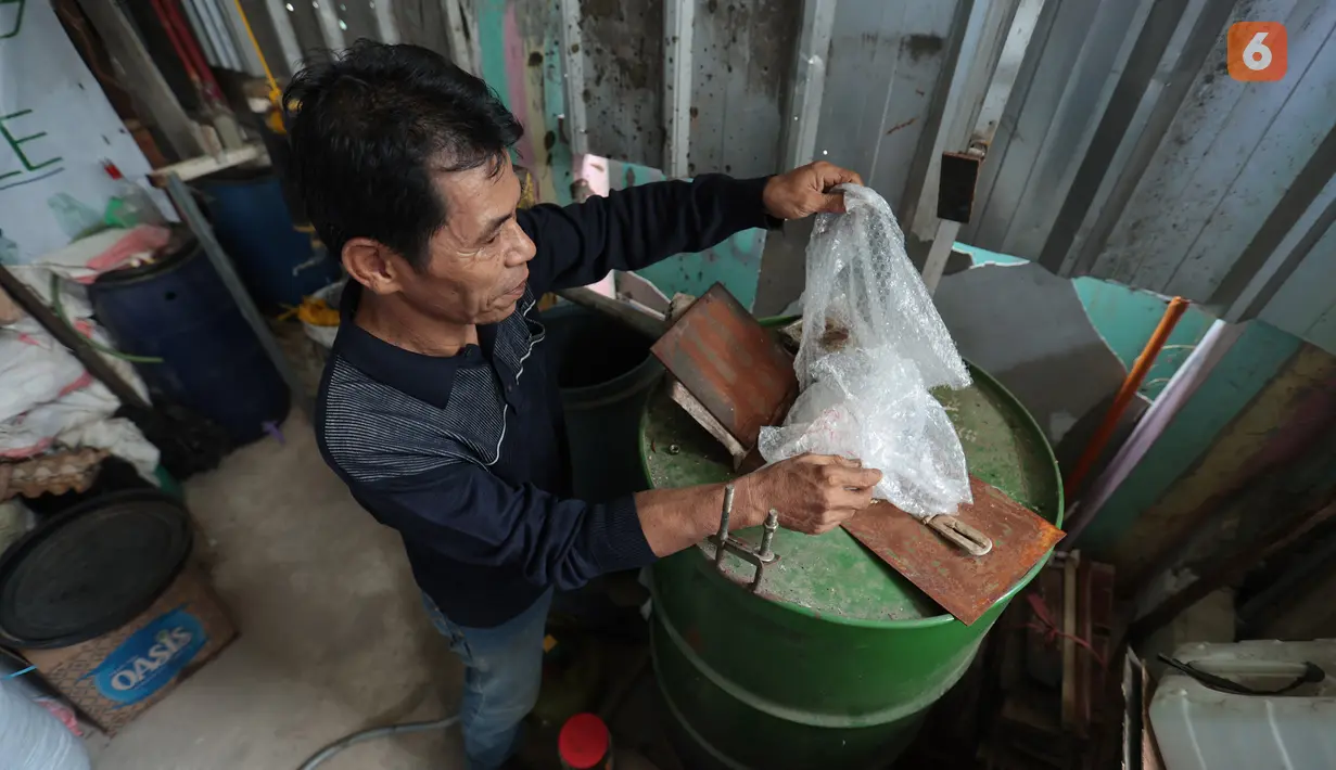 Pengurus RW 01 memproses sampah plastik menjadi bahan bakar alternatif atau petasol di Jakarta, Senin (19/10/2026). Dari satu kilogram sampah, proses ini diklaim mampu menghasilkan sekitar 0,95 liter bahan bakar. (KLY/Budy Santoso)