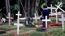 Warga berziarah di area pemakaman khusus dengan protokol COVID-19 di TPU Pondok Ranggon, Jakarta, Jumat (25/12/2020). Momen perayaan Natal 2020 dimanfaatkan sejumlah umat kristiani untuk berziarah mendoakan kerabat yang dimakamkan dengan protokol COVID-19. (Liputan6.com/Helmi Fithriansyah)