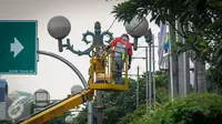 Petugas Suku Dinas Penerangan Jalan Umum (PJU) melakukan perawatan lampu jalanan di Kawasan KH Wahid Hasyim, Jakarta, Selasa (27/9). Perawatan rutin dilakukan untuk memastikan penerangan untuk jalan tetap berfungsi. (Liputan6.com/Faizal Fanani)