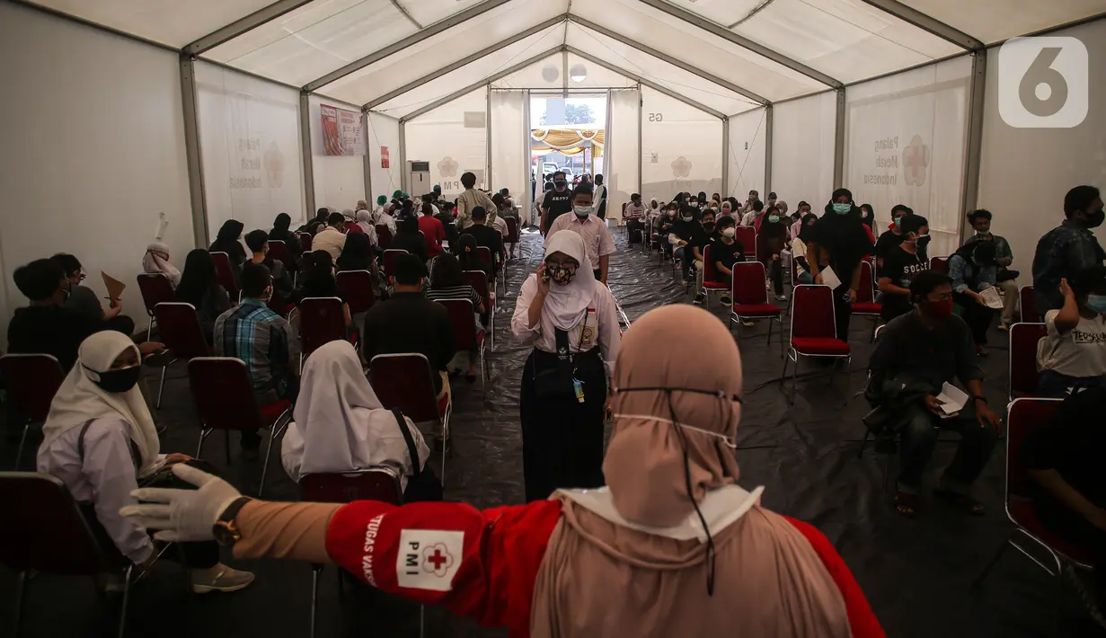 Petugas mengarahkan para peserta vaksinasi covid-19 di Gudang Darurat Nasional Palang Merah Indonesia, Jakarta, Kamis (15/7/2021). PMI turut menggelar vaksinasi massal untuk mempercepat pencapaian target pemerintah untuk mewujudkan kekebalan komunitas. (Liputan6.com/Johan Tallo)
