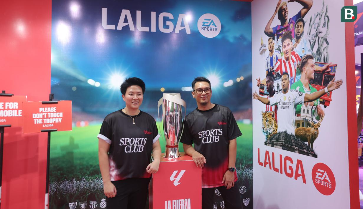Legenda bulu tangkis Indonesia, Liliyana Natsir, Mohammad Ahsan, berpose di depan trofi La Liga pada acara Vidio Sports Festival di Plaza Timur Senayan, Jakarta, pada Sabtu (18/10/2025). (Bola.com/M Iqbal Ichsan)